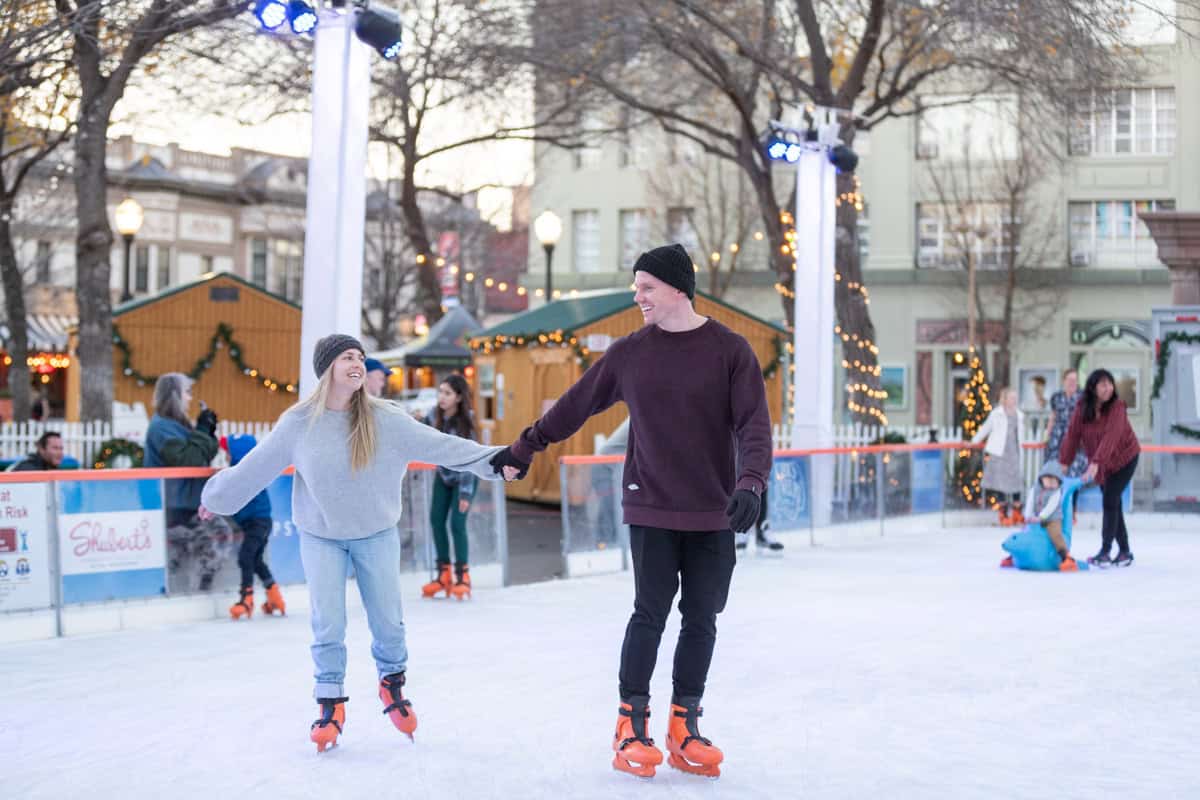 A couple ice skating hand-in-hand at the Chico Ice Rink in the Plaza during a visit to Chico in the winter