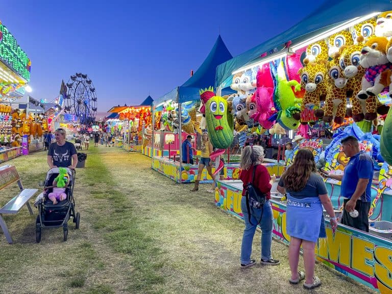 People walking through the carnival games section at the Silver Dollar Fair at the Silver Dollar Fairgrounds in Chico, CA